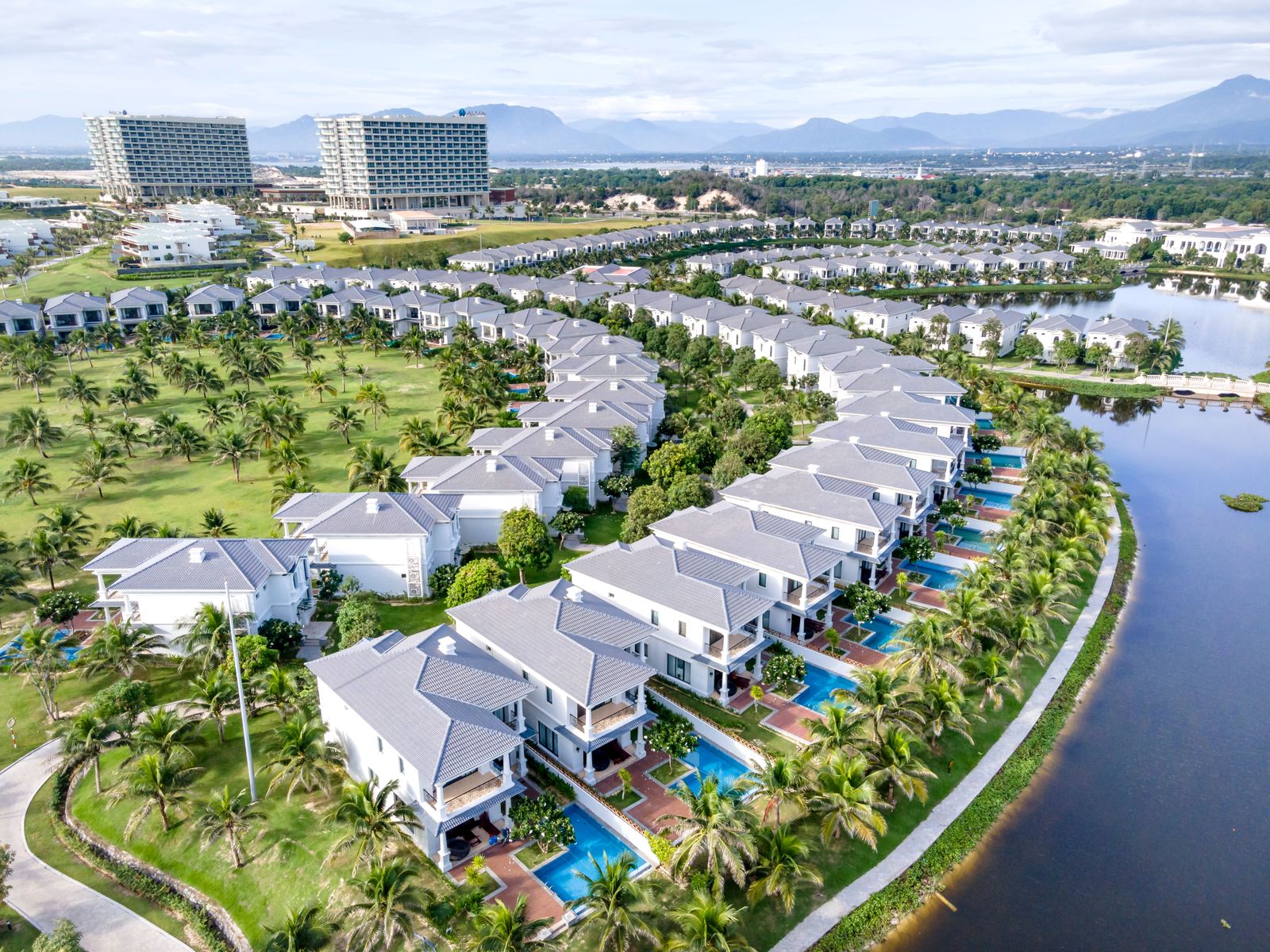 Aerial view of curved rows of villas along a lakeside