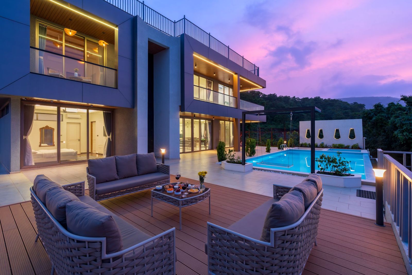 Rooftop terrace with lounge seating and a pool under a violet evening sky